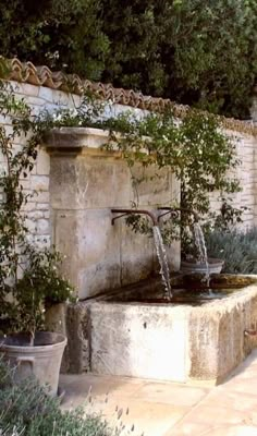 an outdoor fountain with water running from it's faucet to the side