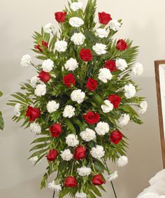 a bouquet of red and white flowers on a stand