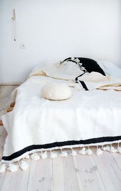 an unmade bed with black and white blankets