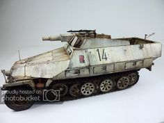 an old toy tank with numbers on the side and wheels, sitting on a white surface