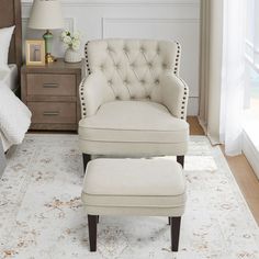 a white chair and ottoman in a bedroom