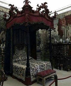 a bedroom with a canopy bed and ornate wallpaper