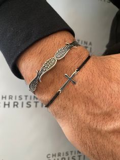 Two different Mens Bracelets that are made from Sterling Silver 925. The first bracelet is an open bangle with a unique wings designand the second bracelet has a unique cross that is passed through a black adjustable cord that is made from solid silver as well. You can wear them together or separetely as well, and you find them only at Christina Christi Store. MATERIALS - Bangle is made from Sterling Silver 925. - Cross is made from Sterling Silver 925 and is passed through a black adjustable cr Solid Silver Bracelets, Stainless Steel Bracelet Men, Silver Bangle Bracelet, Mens Bracelet Silver, Bracelet Men, Summer Bracelets, Mens Beaded Bracelets, Bracelet Cuff, Cross Bracelet