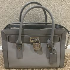 **Bnwt**Made Of Leather; Magnetic Snap Inside Closure; Large Center Zip Compartment; 1 Inside Zip Pocket; 4 Inside Open Pockets And Key Fob; Mk Logo Key Lock; Double Rolled Leather Handles Of 5 Inches Drop; Removable, Adjustable Leather And Chain Shoulder Strap Of 19-22 Inches Drop; Bottom Metal Feet For Protection; Silver Hardware; Comes With Original Tags.Michael Kors Hamilton Large East West Satchel Designer Gray Bag With Branded Hardware, Michael Kors Bags With Silver-tone Hardware For Errands, Michael Kors Bags With Silver-tone Hardware, Chanel Waist Bag, Yellow Tote Bag, Neoprene Tote, Mk Logo, Michael Kors Satchel, Carryall Tote