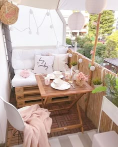 a small balcony with white furniture and pink accessories