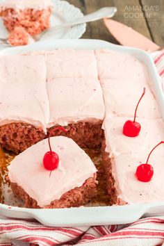 a close up of a cake in a pan with cherries on the top and one slice missing