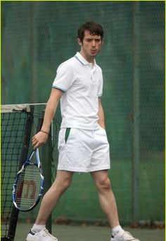 a man holding a tennis racquet on top of a tennis court