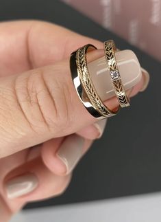 a woman's hand holding two different rings