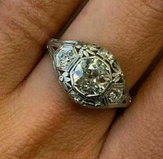 a woman's engagement ring with an old cut diamond in the center and sides