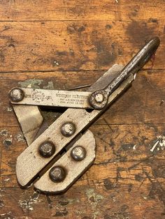 an old pair of pliers sitting on top of a wooden table