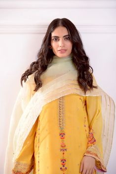 Rendered on pure mustard yellow cotton net with intricate multi hues embroidery in festive tones, the neckline is adorned with gold zardosi handwork craftsmanship, styled with a contrasting pure organza dupatta in mint green with signature Agha Noor gotah motifs and embellished flappers. Turn heads in this beautiful de Semi-stitched Gold Chanderi Lawn Suit, Yellow Lawn Suit With Traditional Drape For Festivals, Traditional Drape Yellow Lawn Suit For Festivals, Bollywood Style Yellow Lawn Suit With Traditional Drape, Anarkali Style Yellow Lawn Suit With Traditional Drape, Yellow Anarkali Lawn Suit With Traditional Drape, Bollywood Style Yellow Lawn Suit In Traditional Drape, Yellow Bollywood Lawn Suit With Traditional Drape, Yellow Organza Sharara For Eid