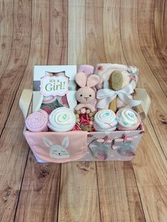 a basket filled with lots of baby items on top of a wooden floor next to a card