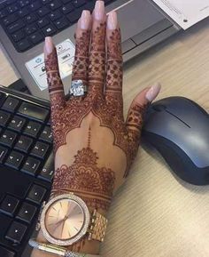 a woman's hand with henna on it next to a keyboard