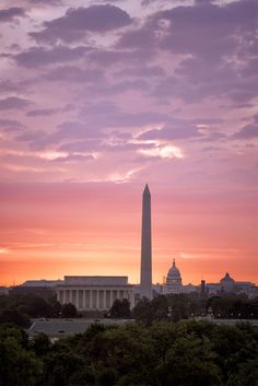 the washington monument is silhouetted against an orange and pink sky