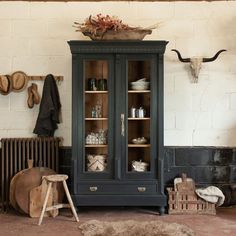 an old fashioned wooden cabinet with many items on it's shelves in a room