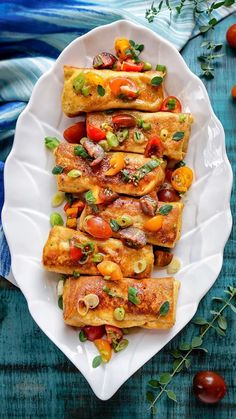 a white plate topped with tofu and veggies on top of a blue table