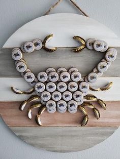 a crab made out of buttons on a wooden board hanging from a wall ornament