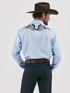 MADE FOR THE TAILORED COWBOY Class up any outfit you're wearing with the Wrangler® Rodeo Ben Western Snap Shirt. Inspired by our early years, this eye-catching take on the cowboy classic is meticulously made down to the smallest detail. It comes with a vintage-inspired pattern, fancy yokes, detailed embroidery, and pearl snaps for a polished look. Dressier than most, this embellished snap shirt for men is crafted from 100% cotton for long-lasting comfort and quality. Blue Western Tops For Rodeo, Western Cotton Shirt For Country Events, Western Style Relaxed Fit Shirt For Ranch, Western Style Relaxed Fit Shirt For Spring, Western Style Blue Tops For Spring, Western Blue Button-up Top, Blue Button-up Shirt For Ranch, Blue Shirt For Rodeo In Summer, Blue Shirt For Rodeo In Spring