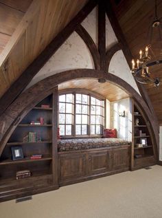 a room with an arched window, bookshelf and built in bookcases