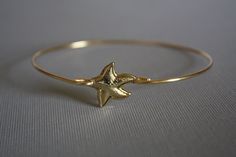 This listing is for one starfish bangle. Made with high quality gold plated , tarnish resistant wire ,gold plated starfish brass stamping. It comes in three different sizes. Small for wrist size 6'' to 6 1/2''..2.5 inches in Diameter (or 8 inch circumference) Medium for wrist size 7'' to 7 1/2'' .2.75 inches in diameter (or 8.5 inch circumference) Large for wrist size 8'' to 8 1/2''. 3 inches in diameter (or 9 inch circumference) Thank you for visiting my shop. Handmade Star-shaped Gold Bracelets, Handmade Gold Star Bracelets, Gold Bracelet With Starfish Charm, Adjustable, Gold Starfish Bracelet With Starfish Charm, Nautical Images, The Bangles, Pearl Bangle, Star Fish, Nautical Jewelry