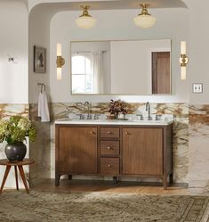 a bathroom vanity with two sinks and mirrors