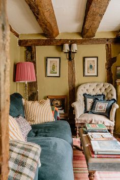 a living room with couches, chairs and pictures hanging on the wall above them