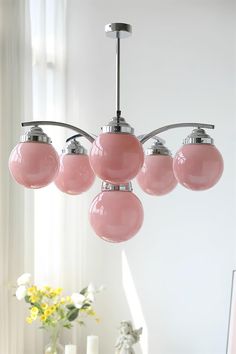 a pink chandelier hanging over a dining room table