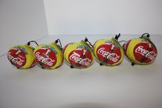 five vintage coca - cola christmas ornaments are lined up