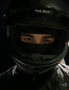 a man wearing a motorcycle helmet in the dark