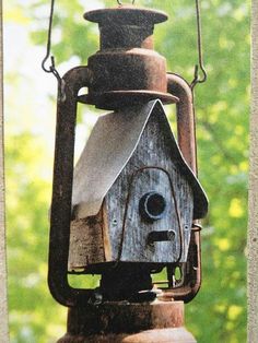 a bird house hanging from a metal pole