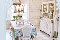 the dining room is decorated in white and has a checkered table cloth on it