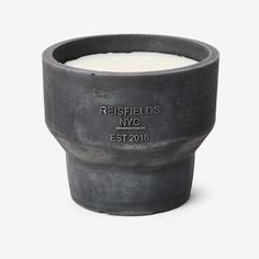 a candle that is sitting on top of a cement cup with the words, relishds nyc est 2016 written on it