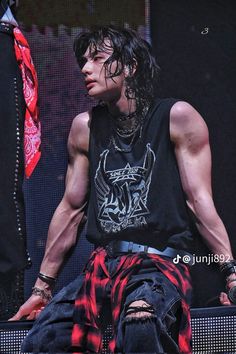 a man with long hair sitting on top of a stage