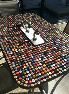 a table covered in beer bottle caps sitting on top of a patio