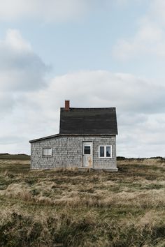 an old house sitting on top of a grass covered field