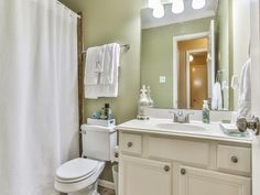 a bathroom with green walls and white fixtures