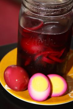 a mason jar filled with liquid next to sliced radishes on a yellow plate