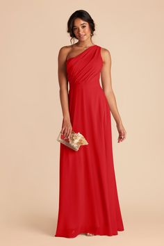 a woman in a long red dress with one shoulder draped over her shoulders and gold clutch