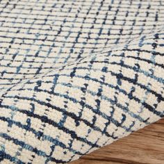 a blue and white rug on top of a wooden floor next to a piece of wood