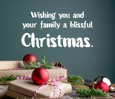 a christmas card with presents and ornaments on a table next to a chalkboard that says wishing you and your family a blissful christmas