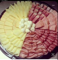 an assortment of meats and cheeses arranged in a circle on a platter