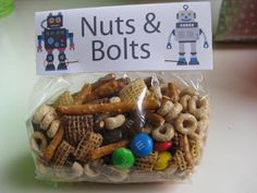 a plastic bag filled with lots of nuts and robot shaped items next to a sign that says nuts & bolts