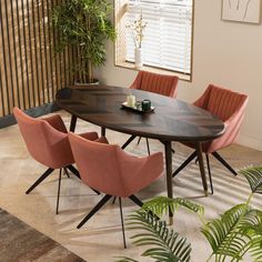 a dining room table with four chairs and a potted plant in the corner next to it