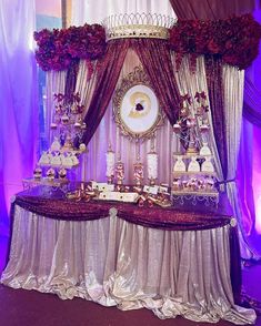 a table with many different types of desserts on it and purple lights behind it