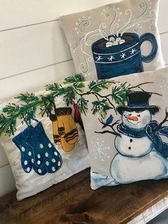 two pillows with snowmen and mittens on them