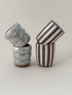 three striped glass containers sitting next to each other