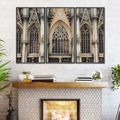 a fireplace in a living room with two paintings on the wall above it and a potted plant