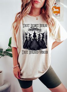 They Didn't Burn Witches They Burned Women Sweatshirt, Spooky Witch Crewneck, Halloween Witchy T-Shirt, Halloween Feminism Shirt *HOW TO ORDER* 1. Select the shirt 𝗦𝘁𝘆𝗹𝗲 2. Select the 𝗦𝗶𝘇𝗲 3. Select the shirt color 4. Select the quantity, 5. Click 𝗔𝗗𝗗 𝗧𝗢 𝗖𝗔𝗥𝗧. If you want to buy more than one, please go back to the listing and repeat the steps. "If you have any question, please send us a message." *BRAND* If you want a specific brand, please send us a message right after you pl Spooky Crew Neck Top With Relaxed Fit, Spooky Relaxed Fit Crew Neck Top, Fall Witchy Graphic Print T-shirt, Spooky Crew Neck Top With Character Print, Spooky Relaxed Fit Top With Letter Print, Funny Cotton Halloween Tops, Funny Halloween Cotton Tops, Funny Cotton Tops For Halloween, Novelty Letter Print Tops For Fall