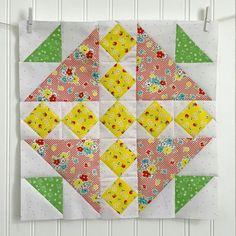 a quilted wall hanging on the side of a white door with green and red flowers