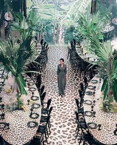 a woman is standing in the middle of an outdoor dining area with leopard print tables and chairs